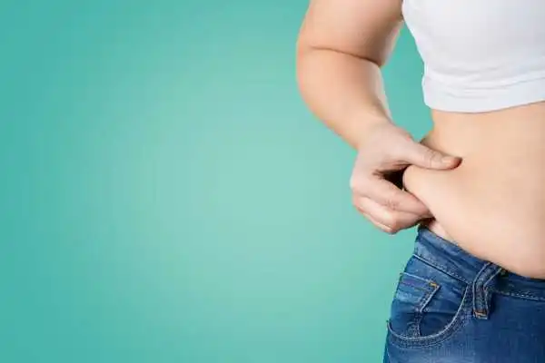 Image of woman pinching her love handles to show weight gain Stroud